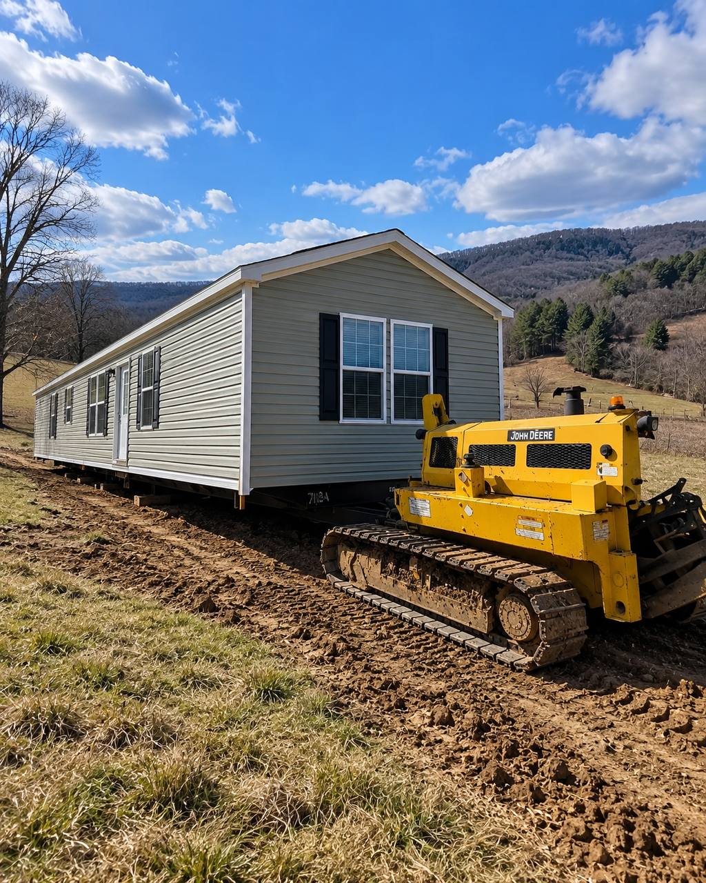 Illustration: Pushing a long single-wide across soft pasture to a hillside pad.